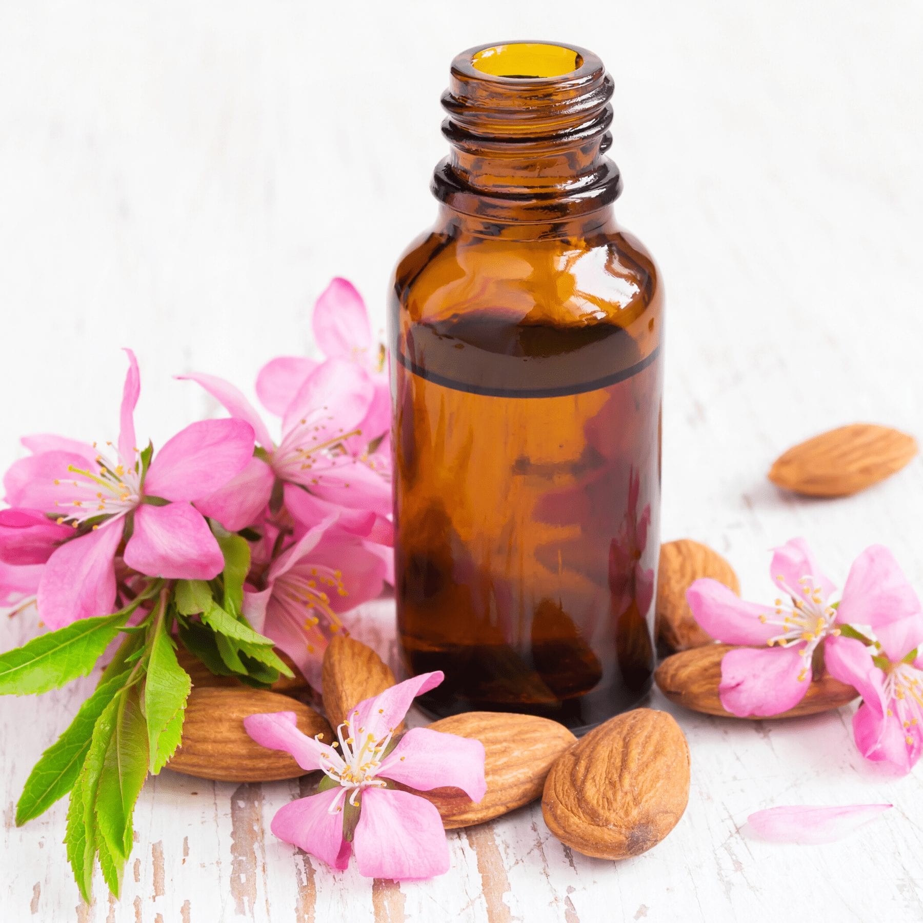 essential oil bottle with spring flowers around it
